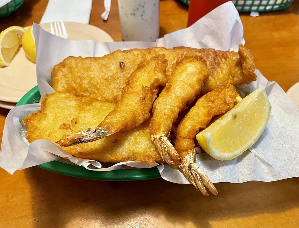 Plated fish, prawns, and hush puppies in a diner style.